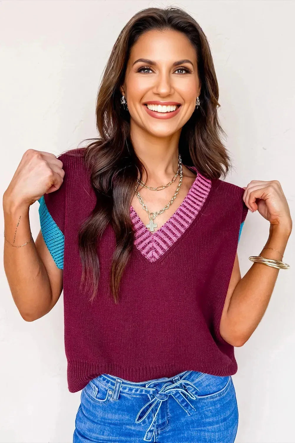 Burgundy loose V-neck sweater with short cuffed sleeves and contrast trim detail.
