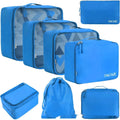 Eight cubic travel packing bags in various solid colours including beige, black, blue, and leopard print patterns