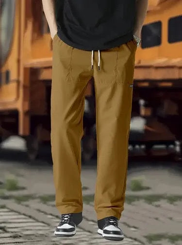 Men's polyester trousers for spring and autumn in light grey, shown in a casual setting.