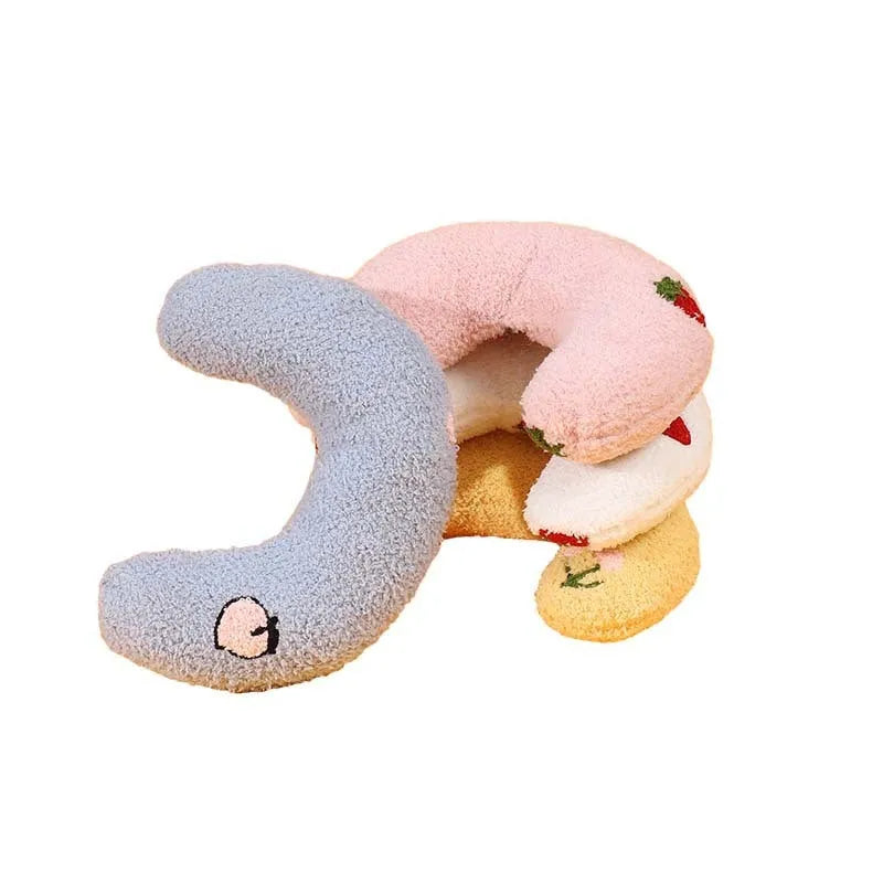 Blue U-shaped half moon cartoon pet pillow for a cat or small dog on a floor.