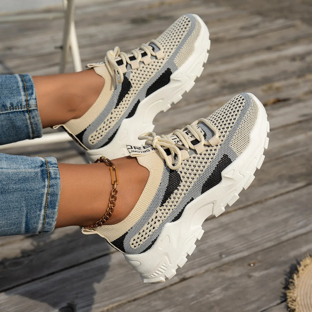 Women's Flyknit mesh lace-up sneakers in a grey colourway on a white background.