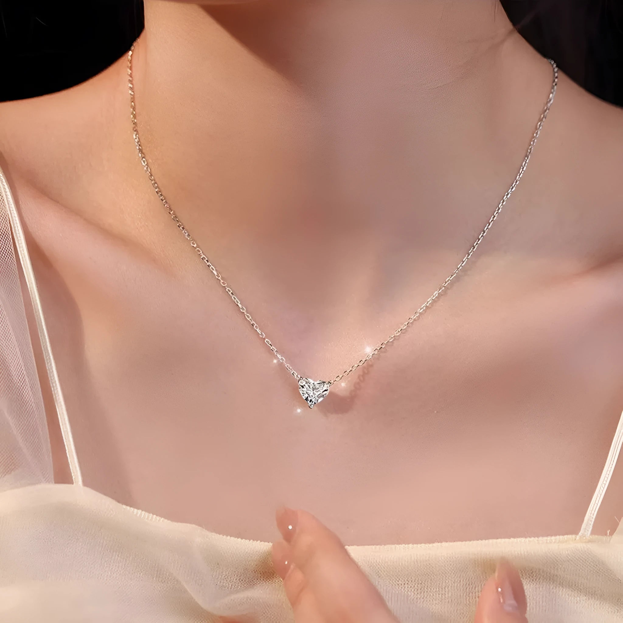 Silver-coloured women's necklace with a simple heart-shaped pendant on a chain.