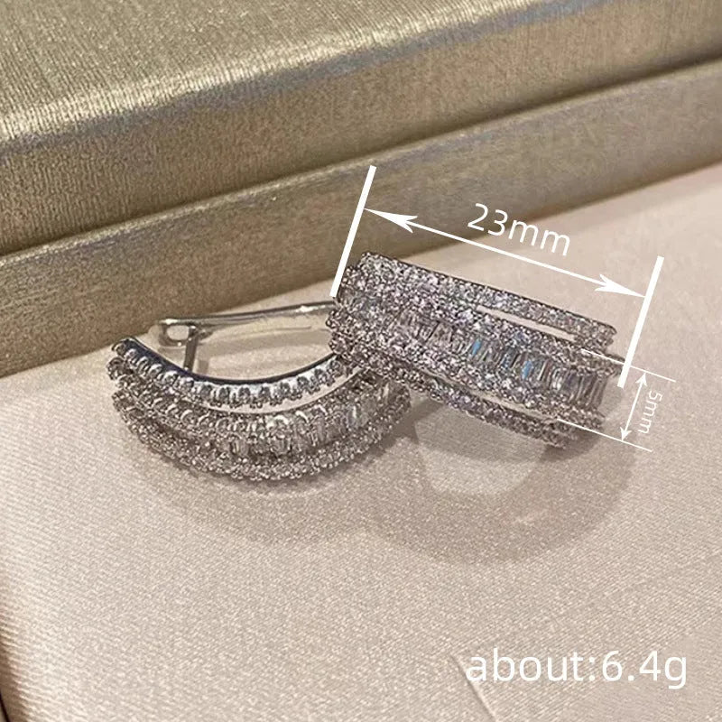 A pair of geometric-shaped stud earrings with zircon stones in a white gold colour.