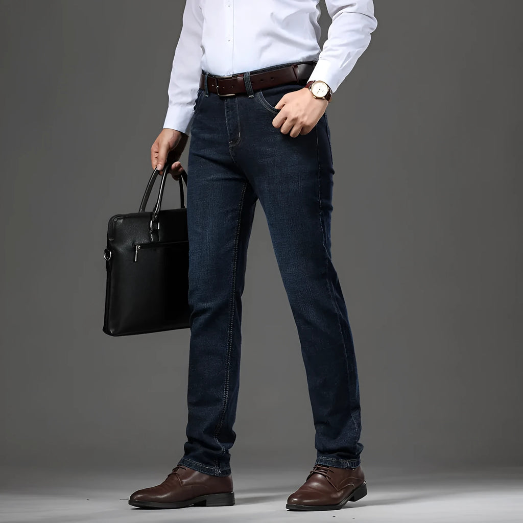 Man wearing loose fit straight-leg stretch jeans in blue denim for a business casual look.