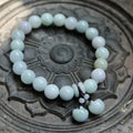 Apple green jade bracelet with carved Maitreya Buddha, gourd, and money bag beads.