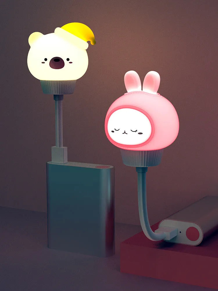 USB portable LED night light in cartoon bear shape with remote control on wooden table.
