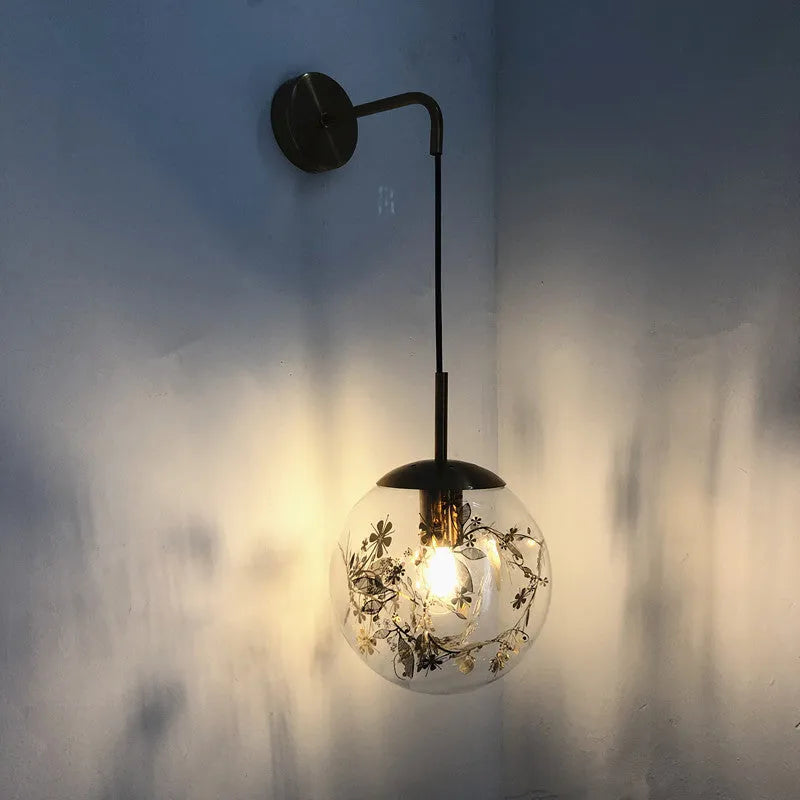 Modern glass wall lamp in golden flower finish mounted beside bed