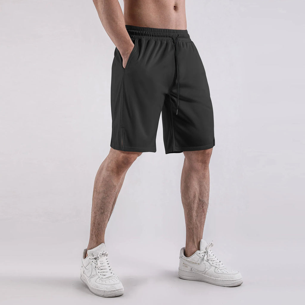 Man wearing black loose-fit quick-dry mesh fitness shorts with an elastic waistband.