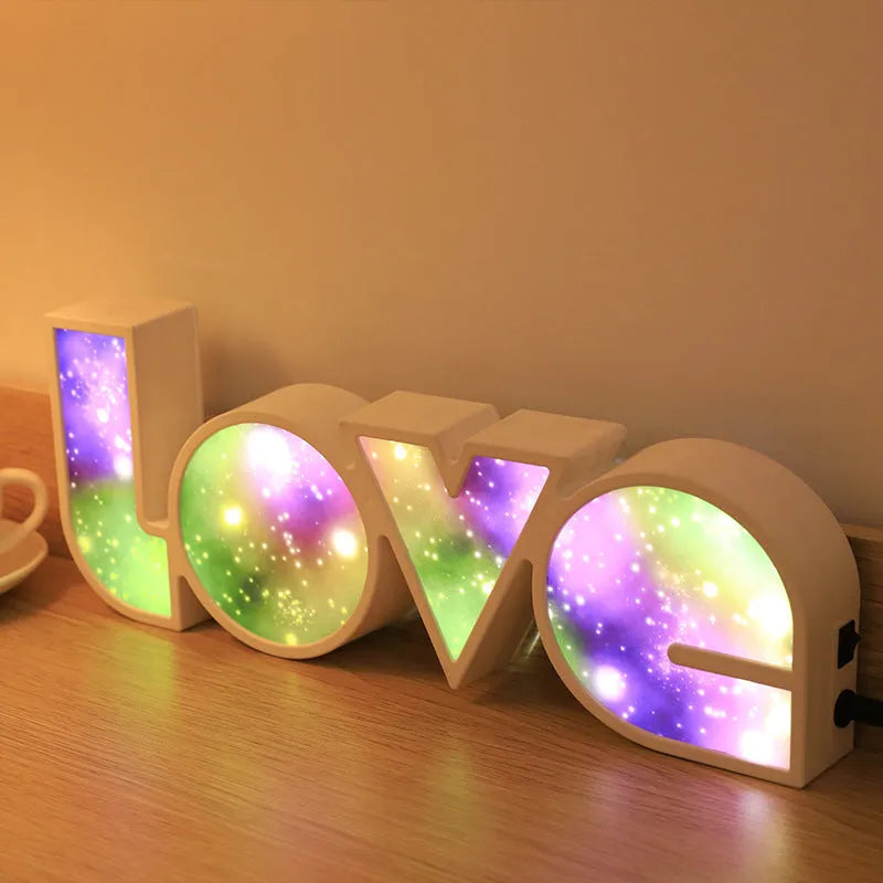 Rainbow-coloured plastic LED light spelling LOVE, standing 35.5cm tall on a table.