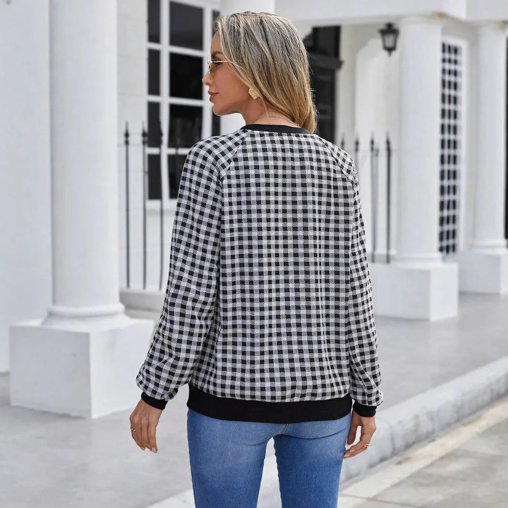 Black plaid pattern long sleeve polyester pullover sweater on a hanger.
