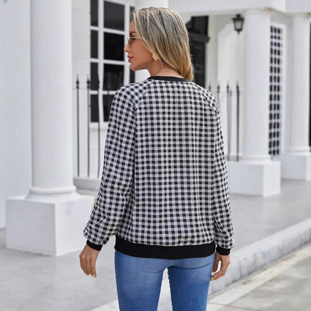 Black plaid pattern long sleeve polyester pullover sweater on a hanger.