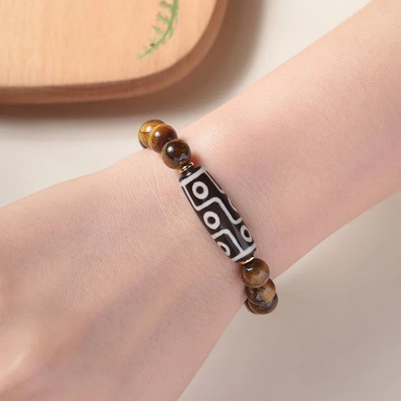 Single circle tigereye Dzi bead Buddhist mala bracelet shown on a wrist.
