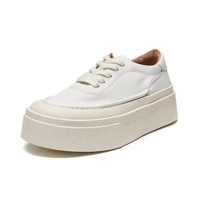 Black and white women's embossed leather platform sports shoes with a round toe and rubber sole.