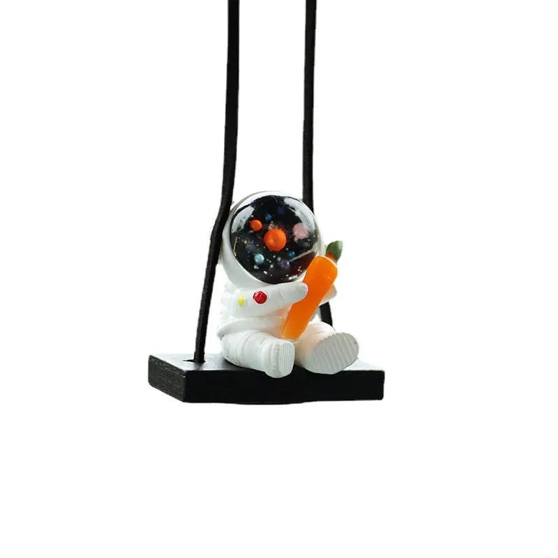 Colourful resin astronaut cartoon character car pendant hanging from a sun visor.