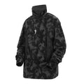Men's black tie dye patterned pullover sweater with turtleneck and drop shoulders on a grey background.