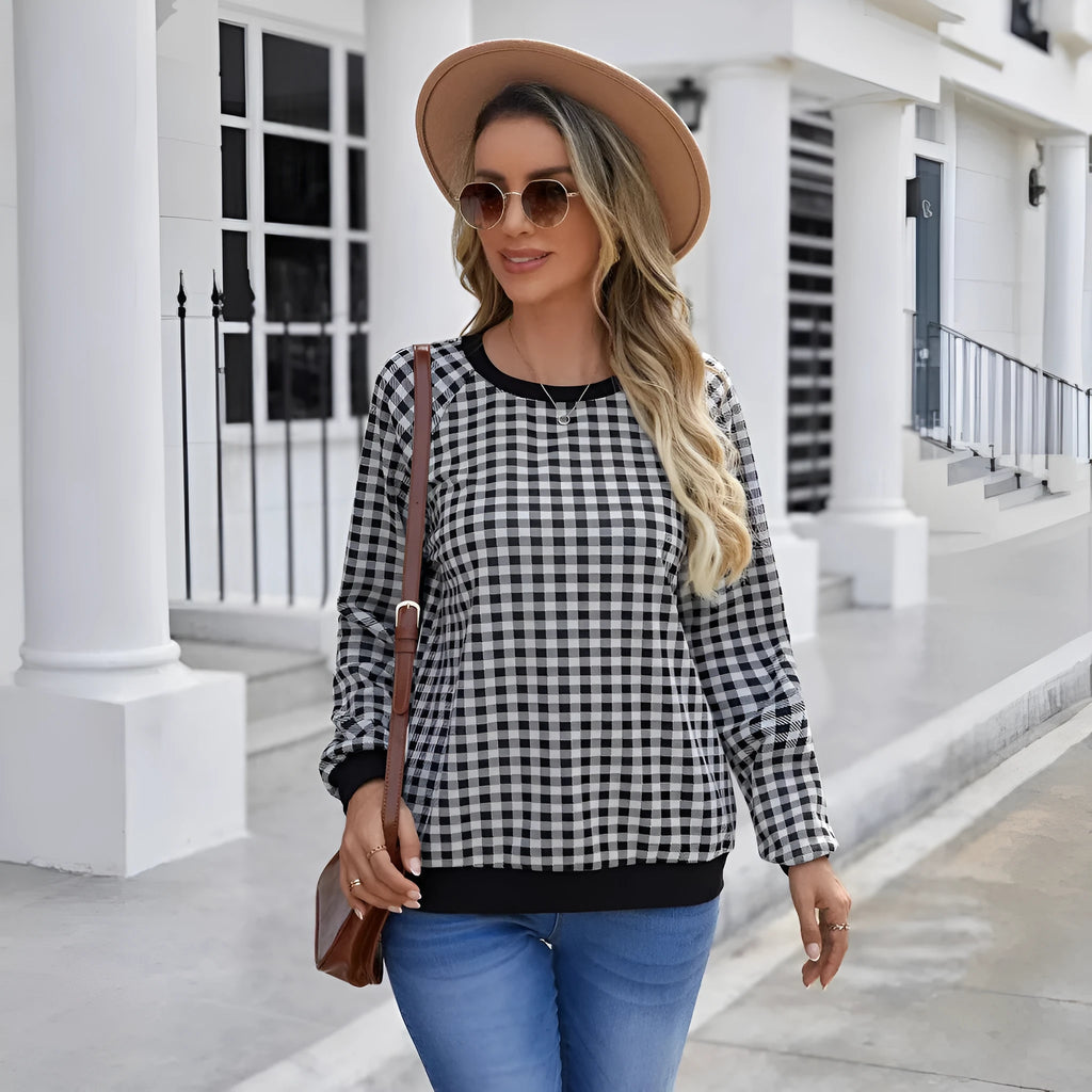 Black plaid pattern long sleeve polyester pullover sweater on a hanger.