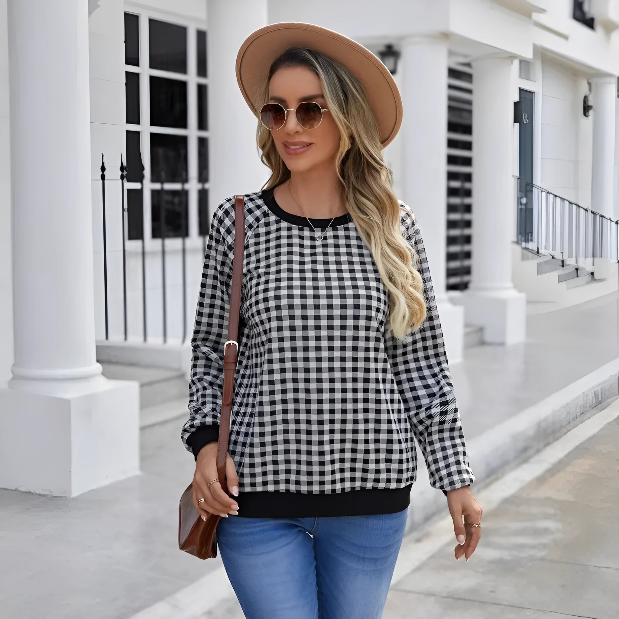 Black plaid pattern long sleeve polyester pullover sweater on a hanger.