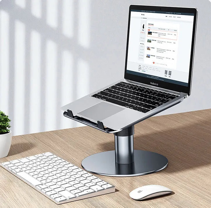 Silver adjustable aluminium laptop stand raised to mid-height with ventilation holes visible.