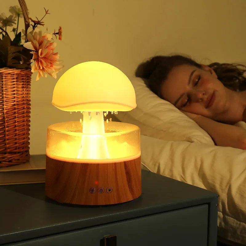 White cloud-shaped humidifier emitting mist with LED lights and falling water droplets