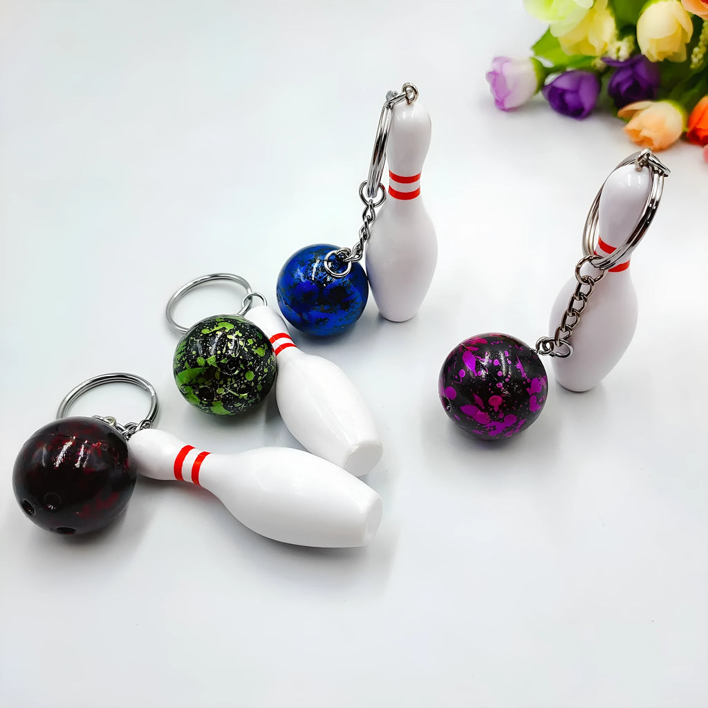 Miniature bowling ball keychain in four colour options: dark red, blue, purple, green