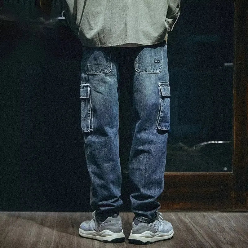 Man wearing blue loose straight-leg denim trousers with a zip fly, showcasing a casual retro style.