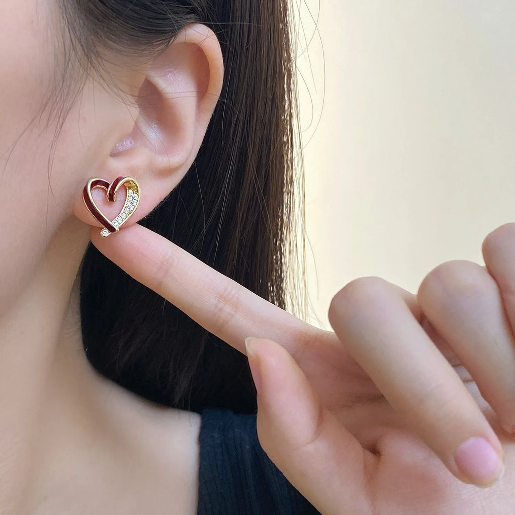 Fashion micro-set zircon asymmetric earrings in copper heart shape with love motif, available in red or white as ear clips or studs