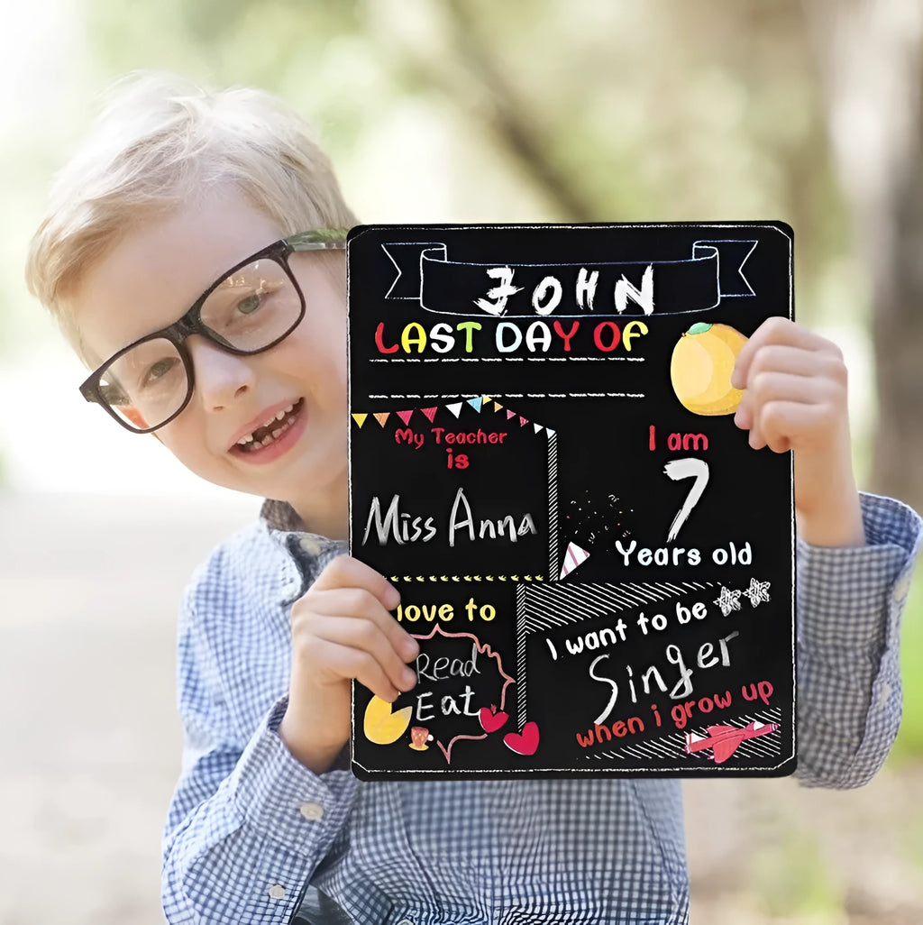 White modern wooden first day of school blackboard sign on a table.