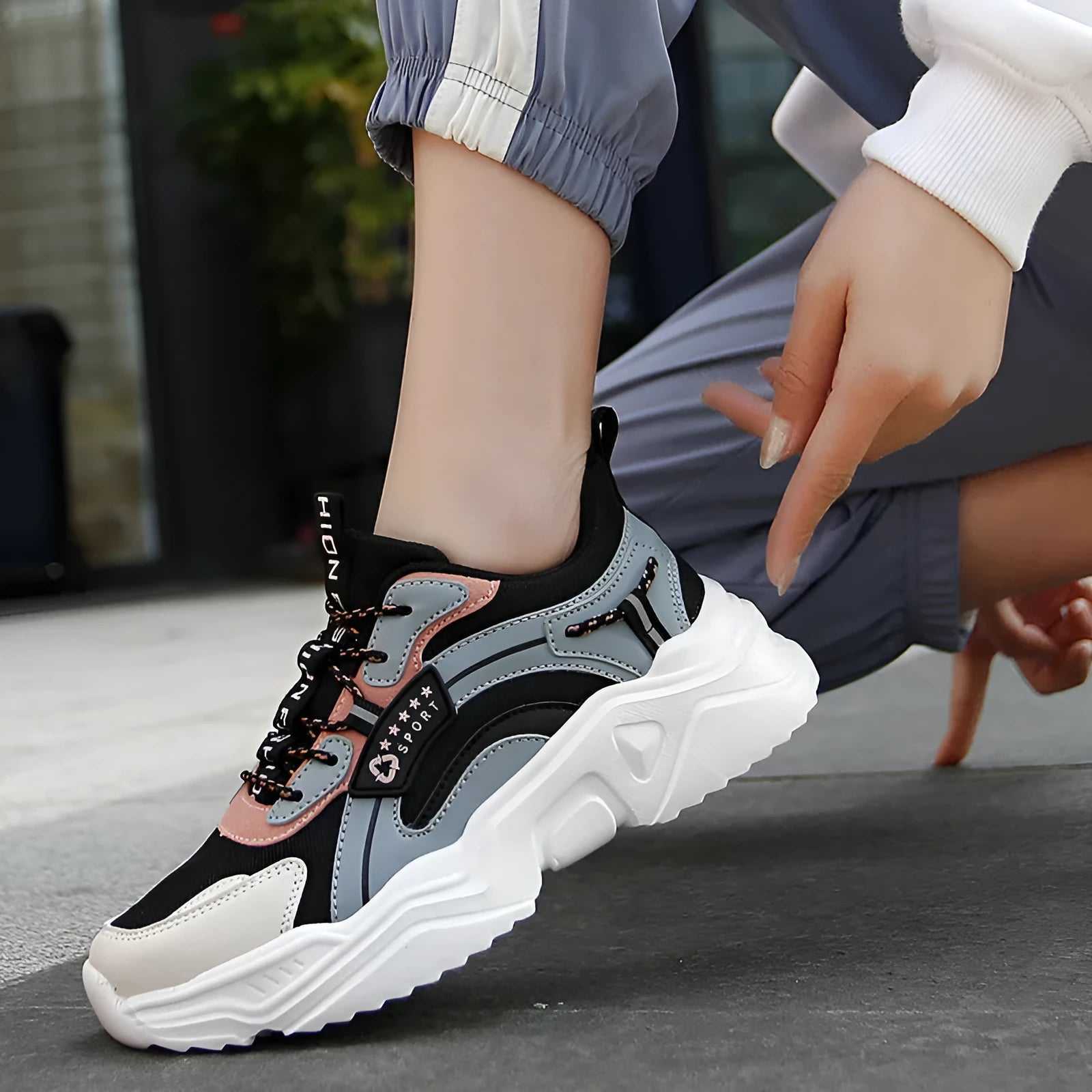 Women's white thick-soled casual sneakers with mesh upper, round toe, and buckle detail.