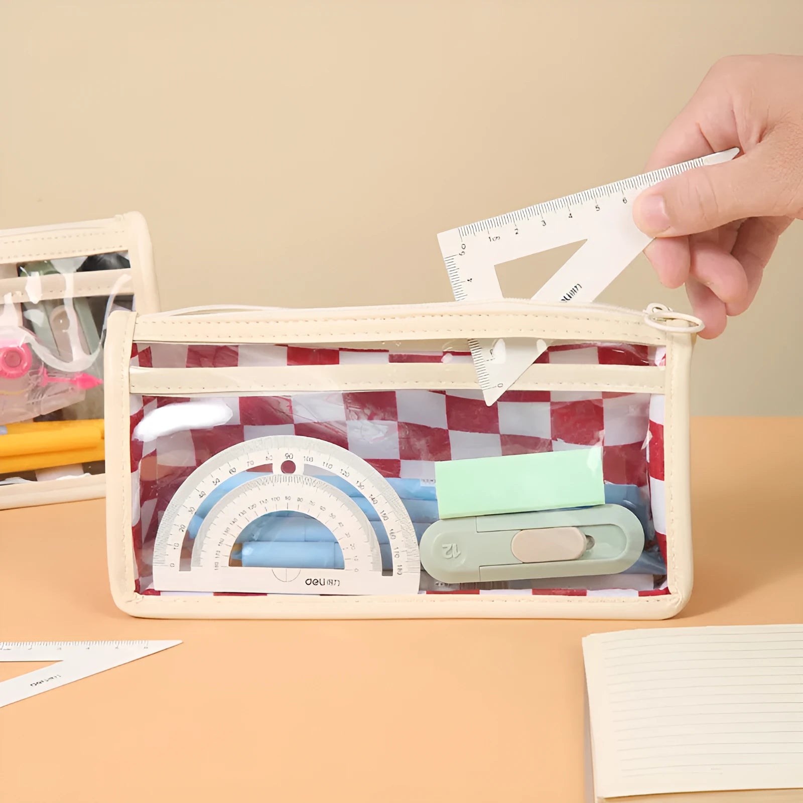 Transparent PVC pencil case with chessboard grid pattern showing pens inside