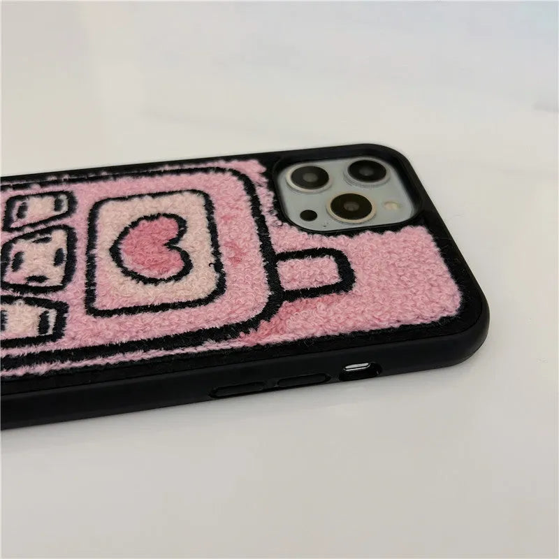 Pink towel embroidered soft TPU back cover case for iPhone models on a table.