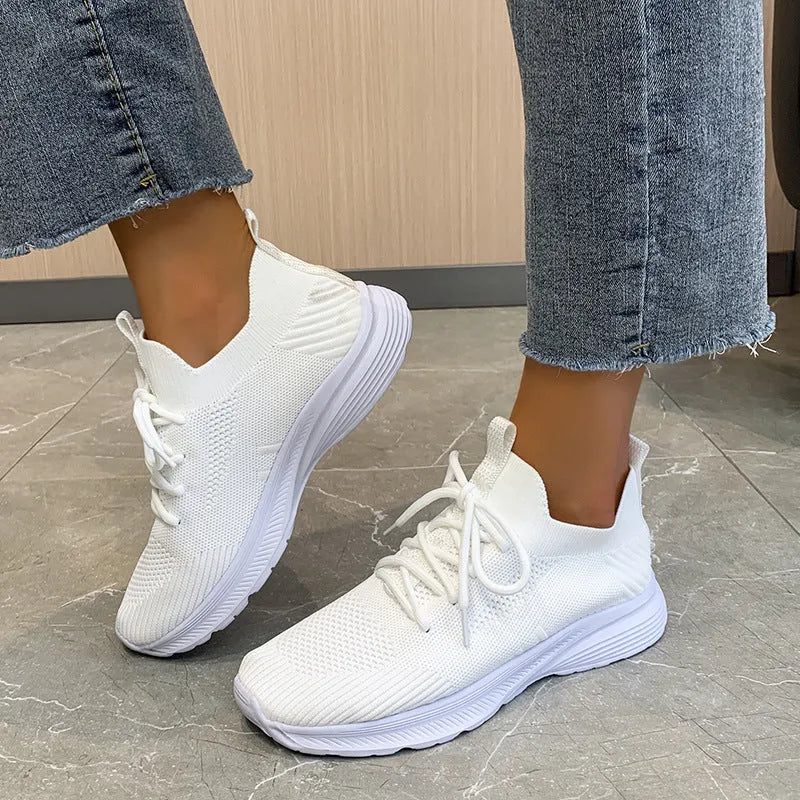 Women's low-top running shoes in creamy white with mesh and Flyknit breathable upper.