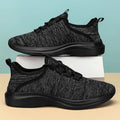 Women's low-top black casual sneakers with mesh upper and lace-up front on a grey background.