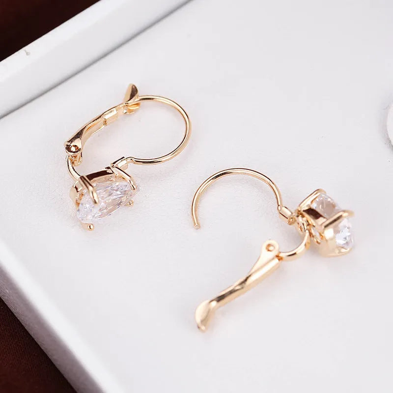 Women's drop-shaped copper earrings with gold finish and decorative platinum inlay.