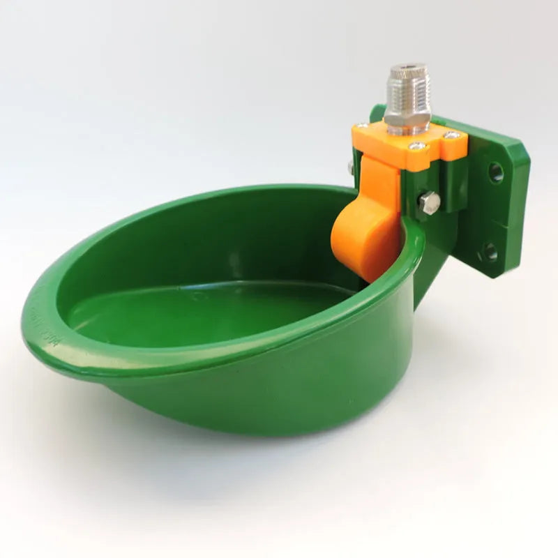 Green plastic automatic water drink bowl for pigs and sheep on a farm.