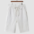 A pair of men's beige linen shorts with a loose, cropped cut and a mid-rise elasticated waistband.