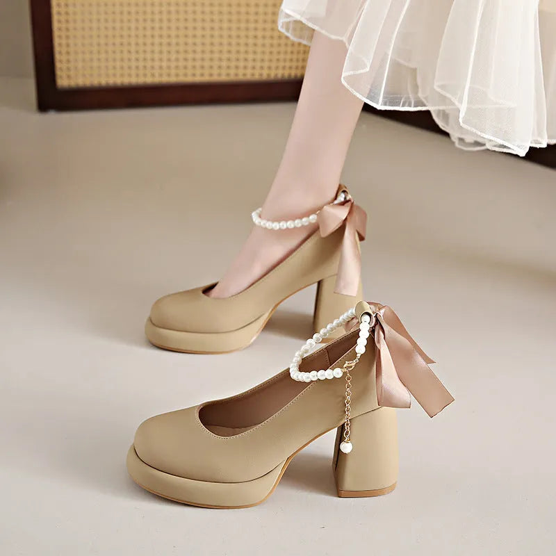 Beige women's Mary Jane shoes with a chunky heel and an ankle-strap buckle on a round toe.