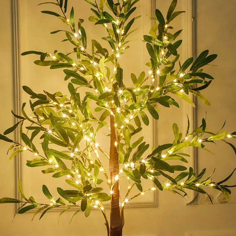 1.8 metre tall artificial olive leaf tree with warm white LED lights illuminated in a garden setting.