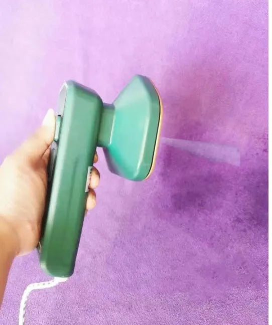 Dark green portable handheld hanging steam iron on a white background.
