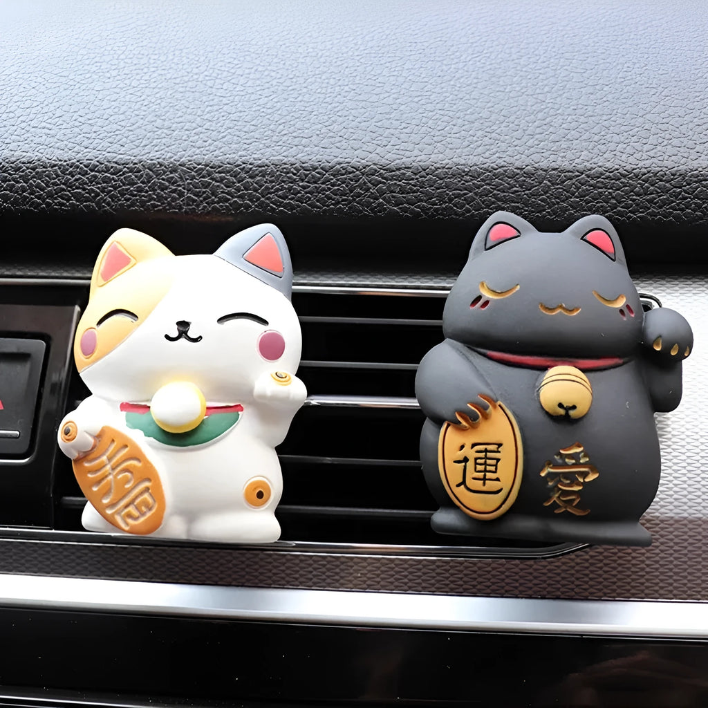 Black cat and white cat resin car vent clip aromatherapy diffuser on a car air conditioning vent.