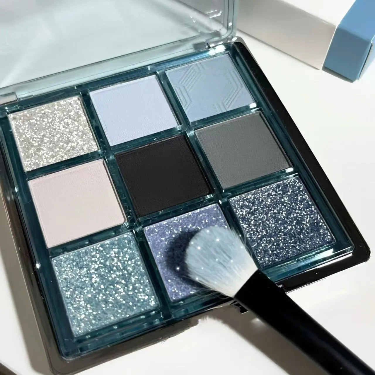 MUGELEEN nine-colour eye shadow palette showing low saturation blue smoked shades with matte and shimmer finishes