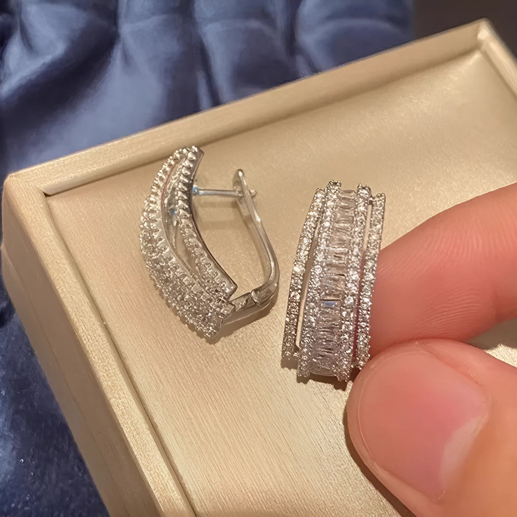 A pair of geometric-shaped stud earrings with zircon stones in a white gold colour.
