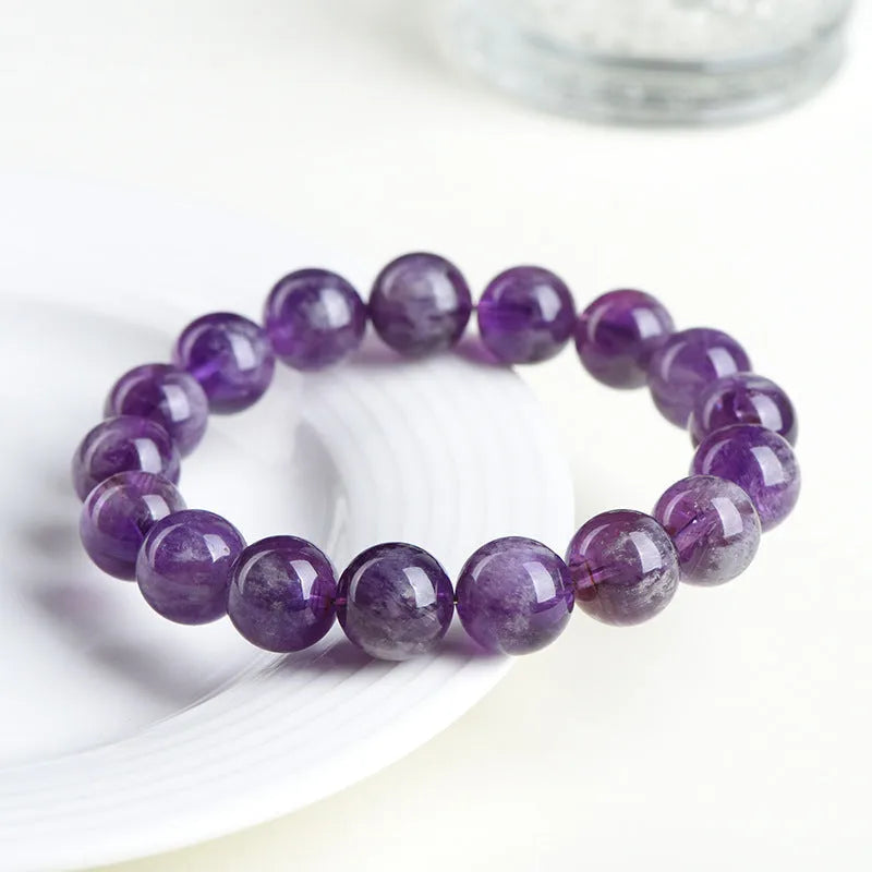 Snow Mountain feather amethyst crystal bracelet with geometric beads and Ruyi elements on a wrist.