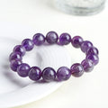Snow Mountain feather amethyst crystal bracelet with geometric beads and Ruyi elements on a wrist.