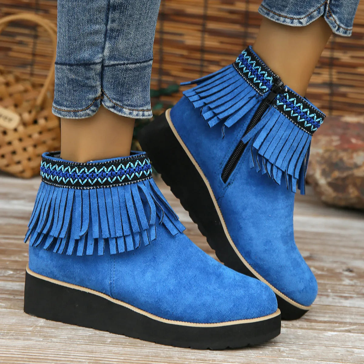Women's black suede ankle boot with wedge heel, platform sole, side zip, and tassel detail.