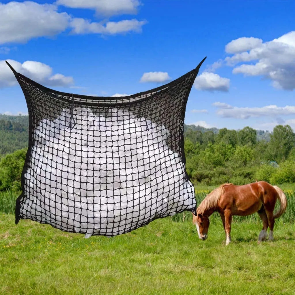 Black woven PE rope grid feeding bag hung on a fence, suitable for horses and cattle.