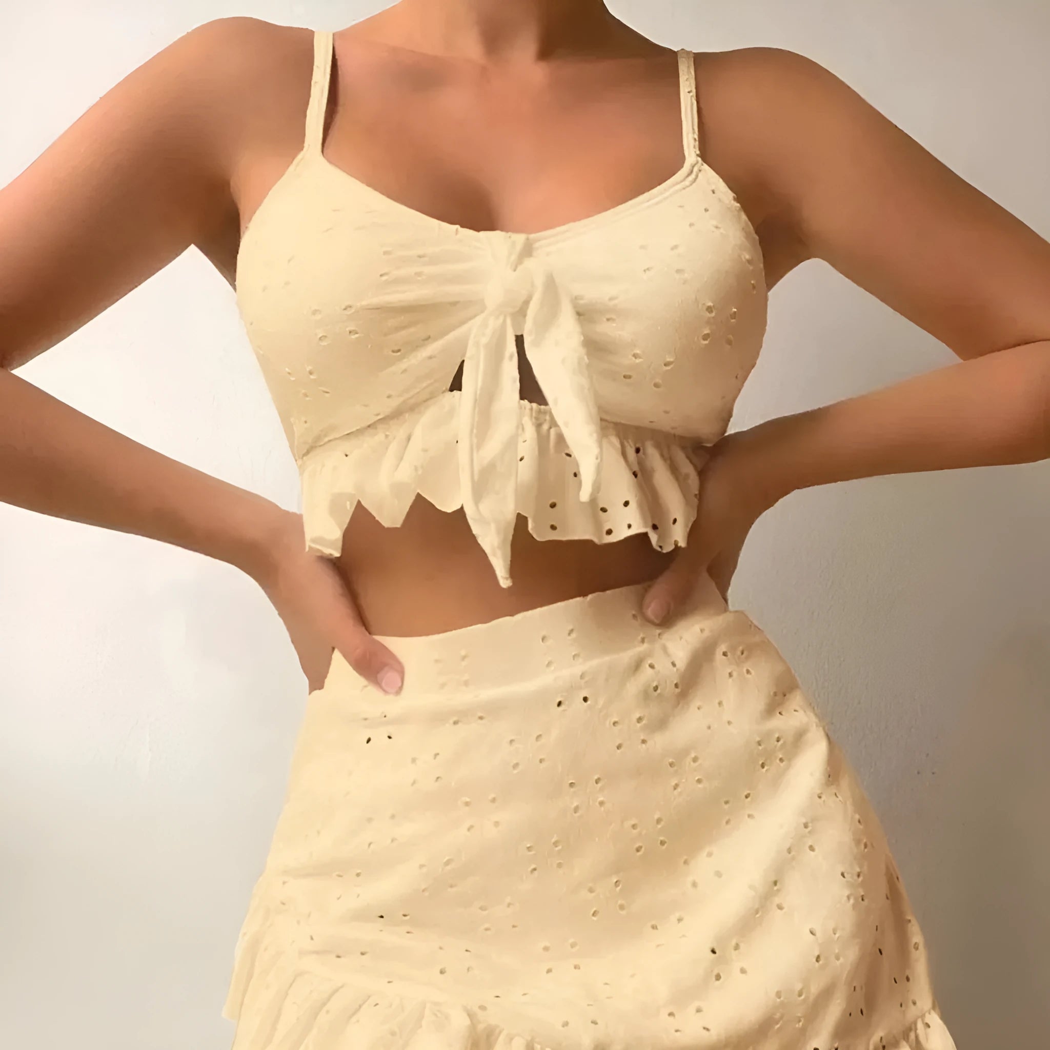 Women's white three-piece bikini swimsuit with a split hip skirt laid flat.