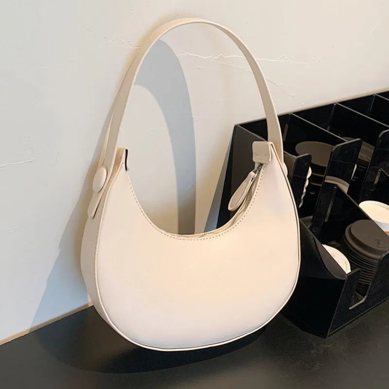 Women's retro dumpling-shaped shoulder bag in PU leather, shown in black, featuring an outer sandwich pocket.