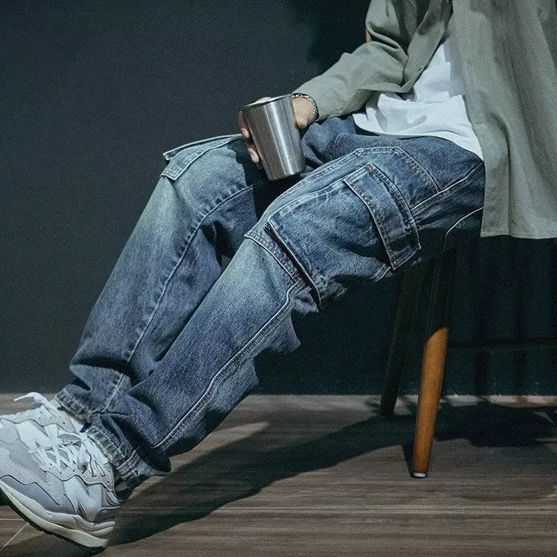 Man wearing blue loose straight-leg denim trousers with a zip fly, showcasing a casual retro style.