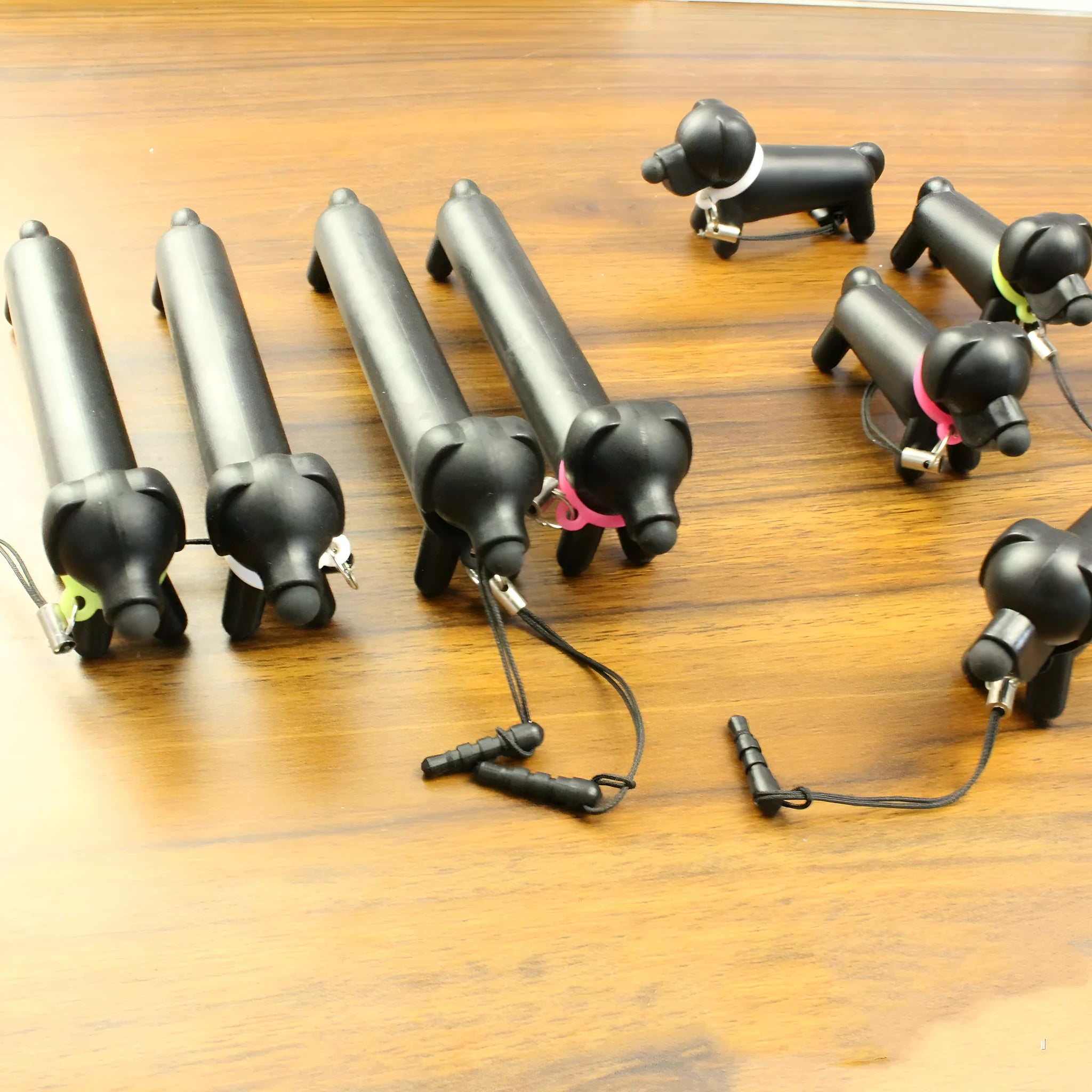 Black dog-shaped touch screen stylus showing length adjustment and phone stand functionality
