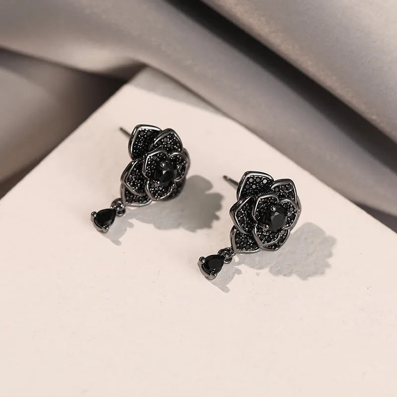 A pair of black rose zircon floral stud earrings with an 18K gold electroplated finish on copper.
